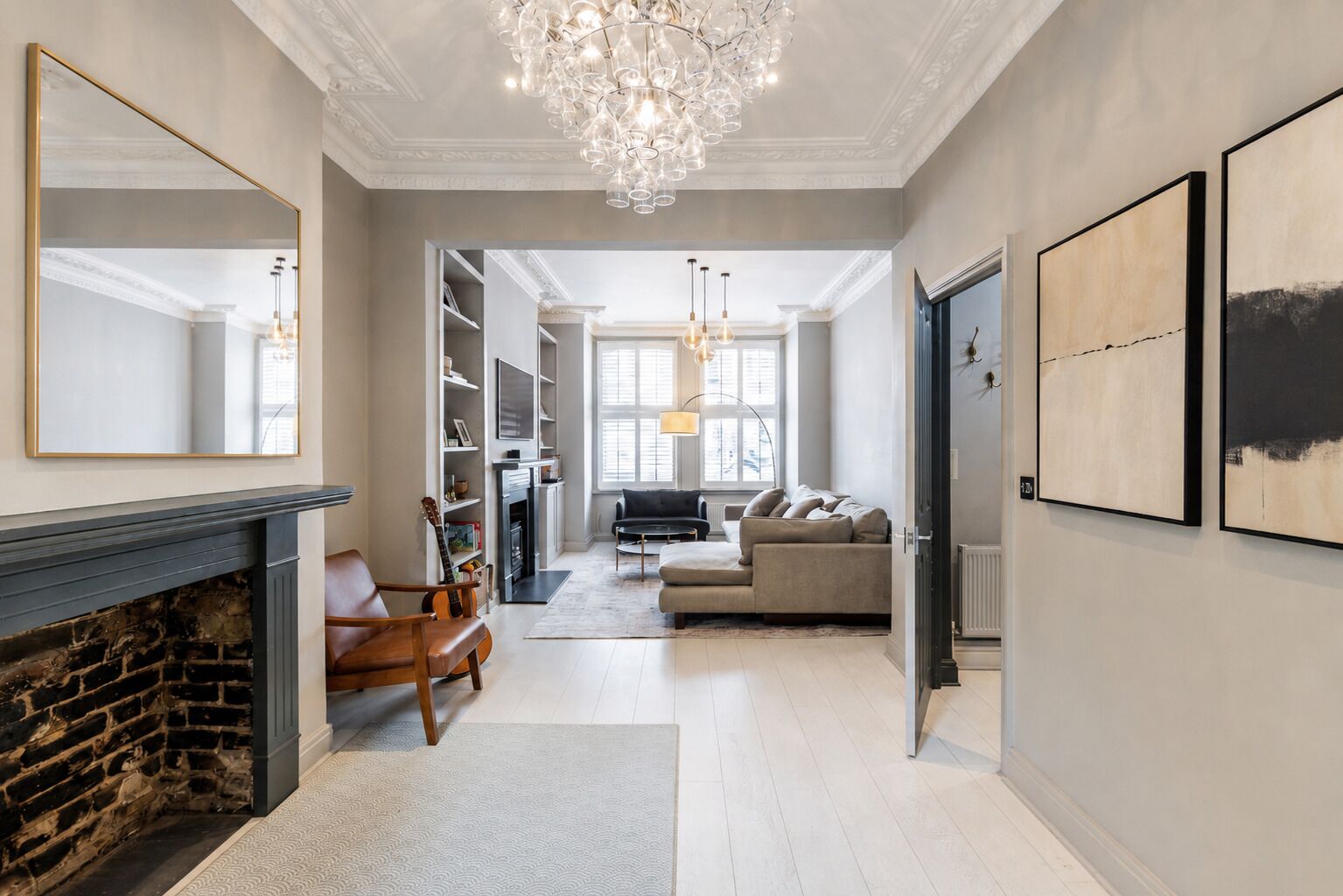 A spacious living room with a fireplace, a sofa, and a chandelier.