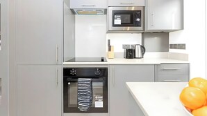 Eine moderne Küche mit Mikrowelle, Backofen und Kaffeemaschine.