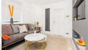Ein modernes Wohnzimmer mit einer Couch, einem runden weißen Tisch und einer Heizung.