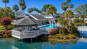 Un resort con piscina, un pabellón y palmeras.