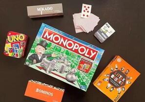 A Monopoly board game, UNO cards, and a Dominoes box. - In the heart of La Marsa - Beach - Wi-Fi - Quiet - Kitchen (La Marsa)