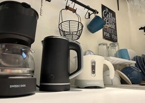 Eine Küche mit Kaffeemaschine, Wasserkocher und einer Kaffeetafel.