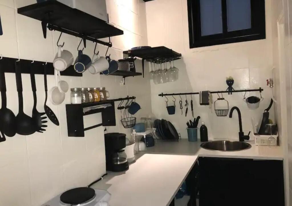 Eine Küche mit hängendem Kochgeschirr, einer Kaffeemaschine und einem Spülbecken.