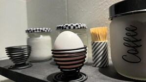 Una encimera de cocina con una cafetera, un tarro de café y un montón de palillos.