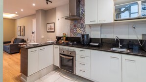 A modern kitchen with white cabinets, a stainless steel range hood, and a built-in oven. - 9 min From Copacabana Beach Ml905 (Rio de Janeiro)