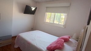 A bedroom with a bed, a wardrobe, a television mounted on the wall, and a window with blinds. - Apartment in Málaga: City, Tourism & Beach (42 meters) (Ma)