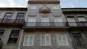 A multi-story building with patterned tile facades, balconies with wrought iron railings, and multiple windows. - Downtown Apartment Porto by Liiiving (Porto)