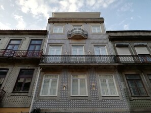 A multi-story building with patterned tile facades, balconies with wrought iron railings, and multiple windows. - Downtown Apartment Porto by Liiiving (Porto)