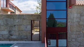 Ein modernes Gebäude mit einer Steinwand, einem Pool und einer Glastür.