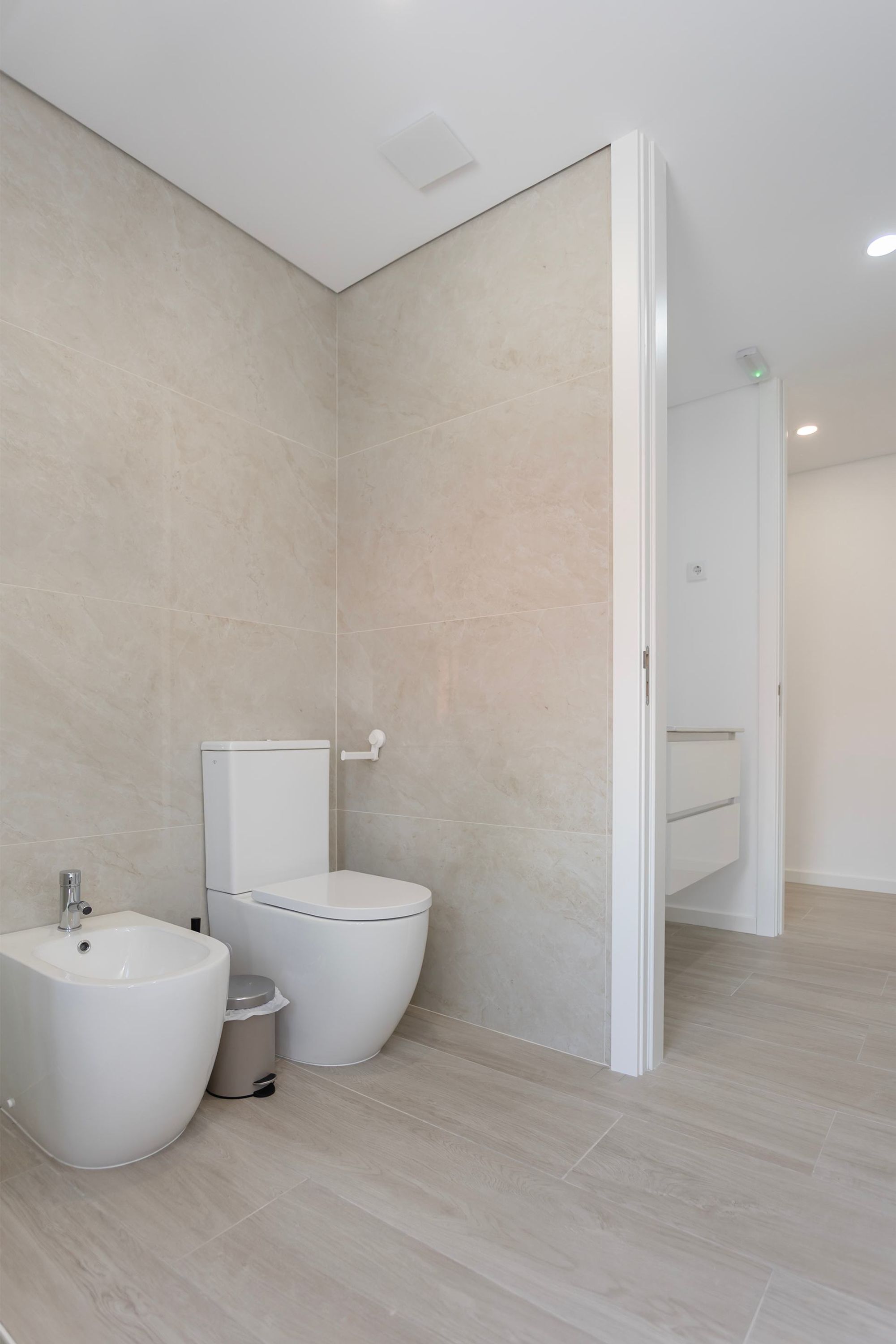 Une salle de bain moderne équipée d’un bidet, de toilettes et d’un lavabo.