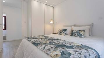 Ein Schlafzimmer mit einem Bett, einem Nachttisch, einem Spiegel und einer Tür.