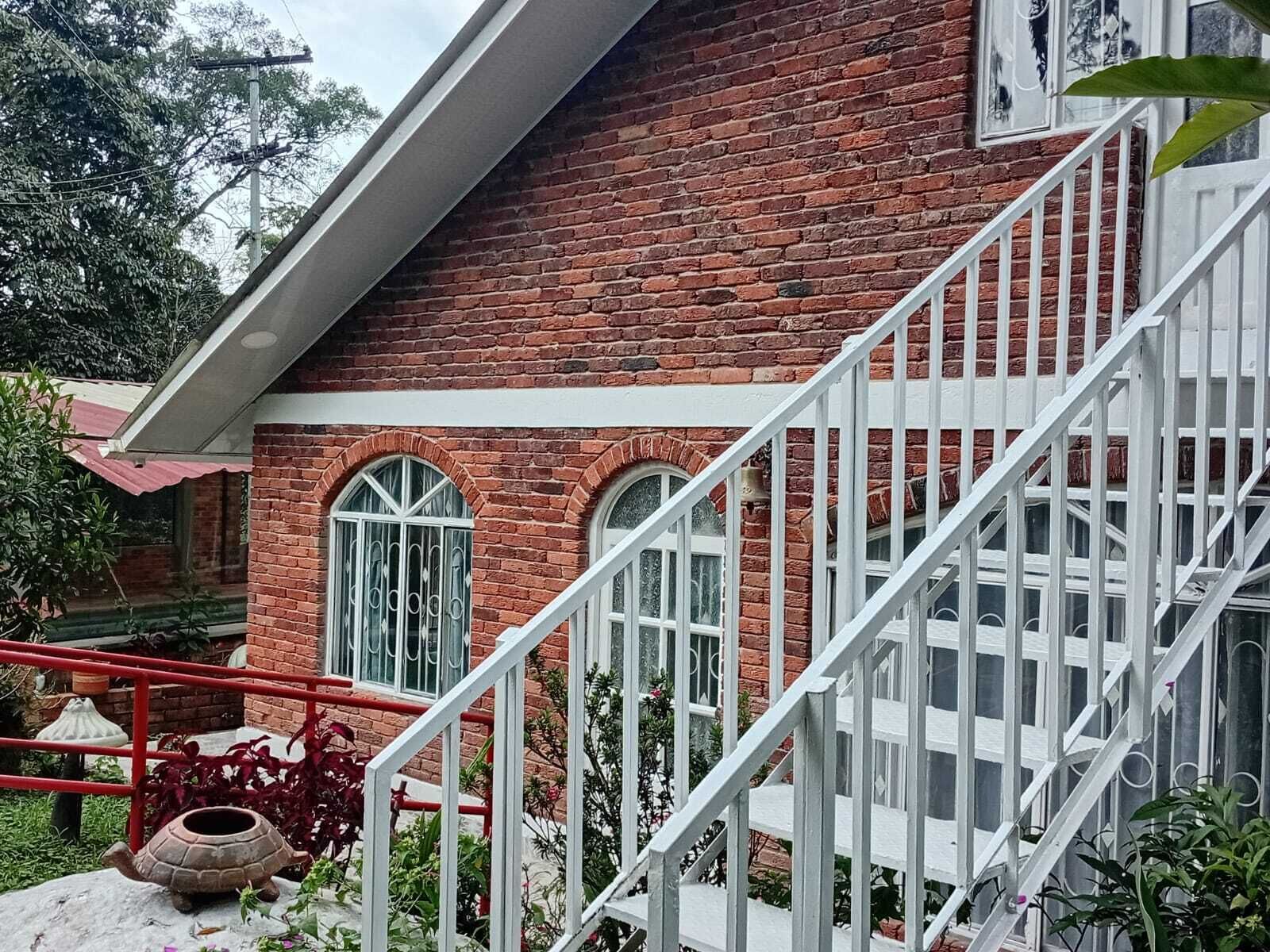 A brick building with a white staircase and arched windows.