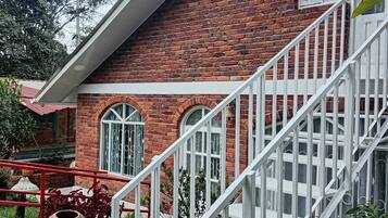 A brick building with a white staircase and arched windows.