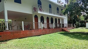A two-story building with a covered porch and a fenced yard.
