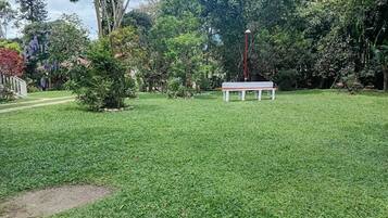 A grassy outdoor area with a bench and a lamp post.