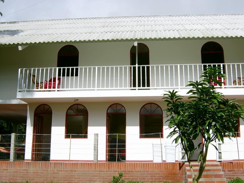 A two-story building with a balcony on the upper floor and a staircase leading to the entrance.