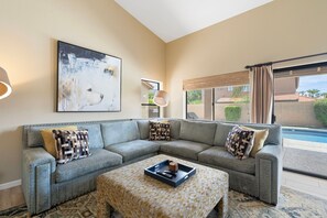 A living room with a sectional sofa, a coffee table, and a painting on the wall. - Desert Retreat with Pool Near Golf & Hiking (Scottsdale)
