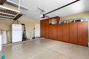 Eine geräumige Küche mit Kühlschrank, Schränken und einem an der Decke befestigten Projektor.