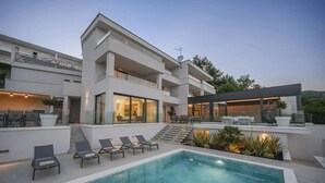 A modern multi-story building with a swimming pool, outdoor seating, and a covered patio area. - Villa Maremont Nearby Opatija - Crovillas (Opatija)