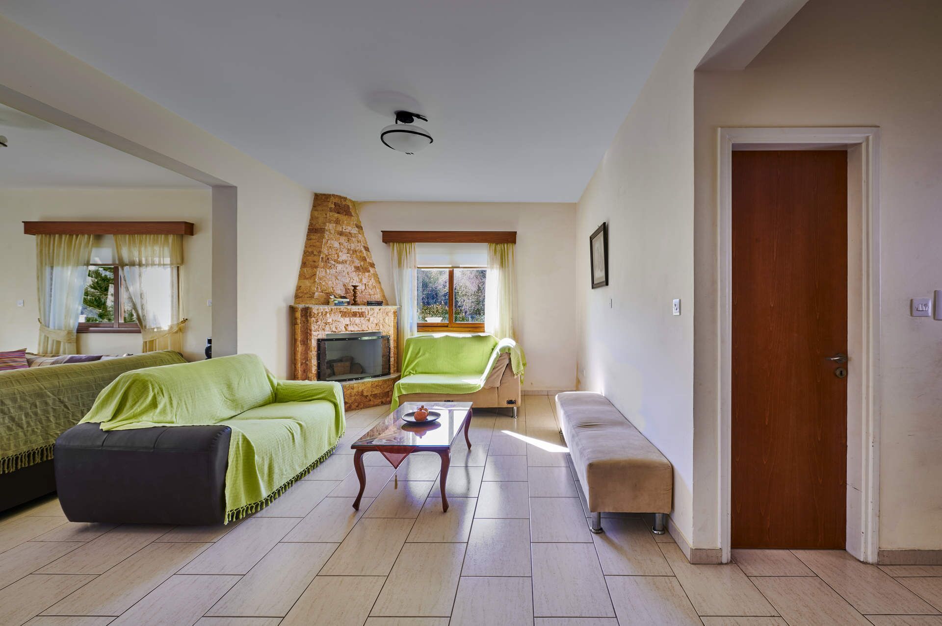 Un salon avec une cheminée, deux canapés, une table basse et une porte.