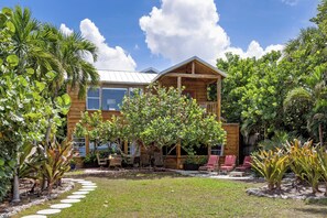 A wooden two-story building with a covered patio area and outdoor seating. - The Original Beach House: A Timeless Gulf-Front Retreat on Siesta Key Beach (Sarasota)