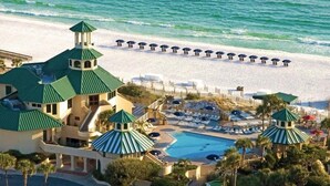 Ein Resort mit Pool, Strandliegen und Blick auf den Strand.