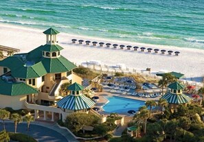 Ein Resort mit Pool, Strandliegen und Blick auf den Strand.