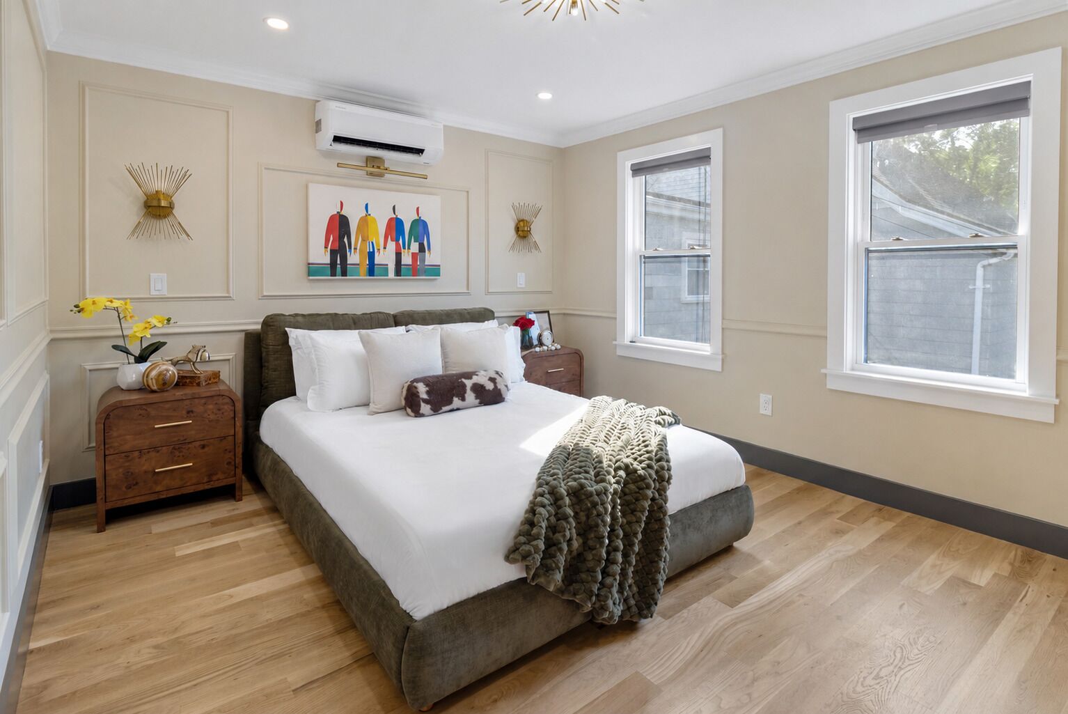 A bedroom with a large bed, a nightstand, a dresser, and a window.