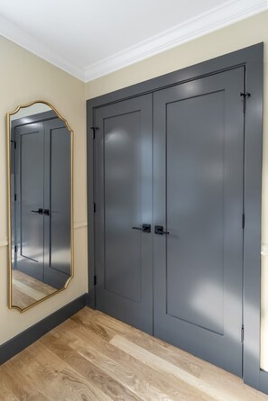 A room with a large mirror, two grey doors, and a wooden floor. - Cambridge Designer Home / Harvard, MIT, Boston (Cambridge)