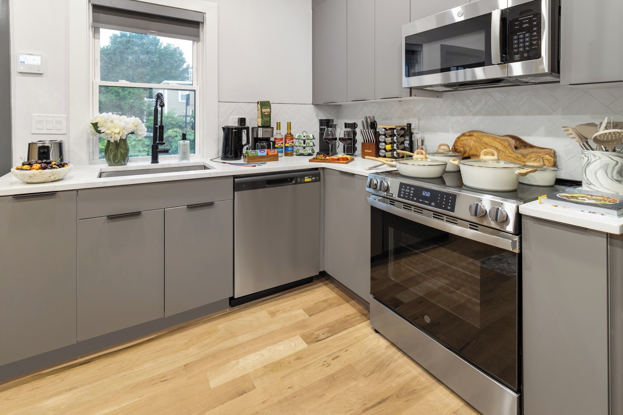 A modern kitchen with stainless steel appliances, a dishwasher, and a microwave.