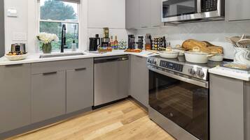 A modern kitchen with stainless steel appliances, a dishwasher, and a microwave.
