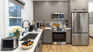 A modern kitchen with stainless steel appliances, a built-in oven, and a microwave.