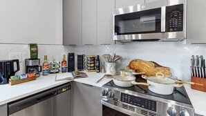 A modern kitchen with stainless steel appliances, including a microwave, coffee maker, and stove.