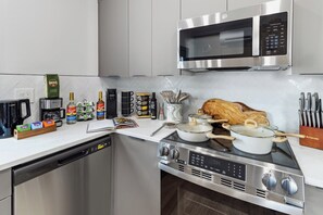 A modern kitchen with stainless steel appliances, including a microwave, coffee maker, and stove.