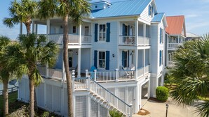 A multi-story house with a balcony, a covered porch, and a staircase leading to the entrance. - Spacious family home sunrise and sunset views, close to beach and resort amenities (Saint Helena)