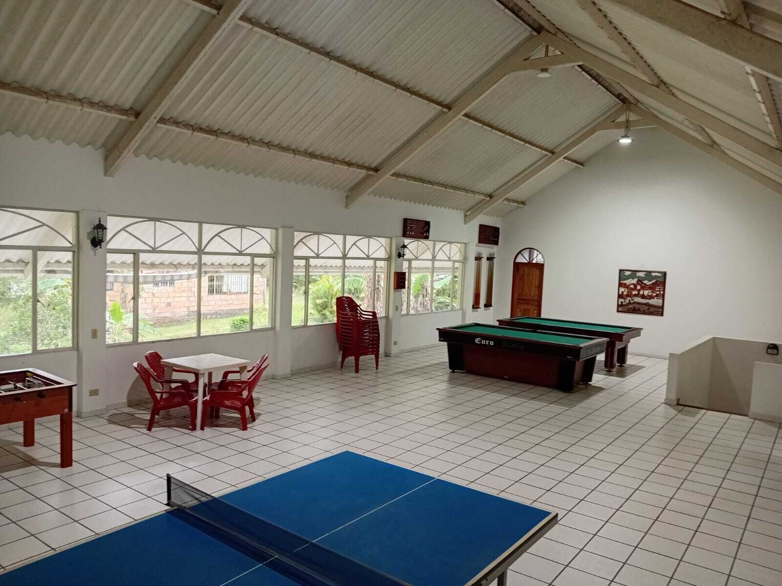 A room with a pool table, a ping pong table, and a billiards table.