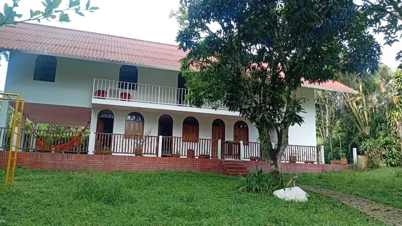 A two-story building with a balcony, arched windows, and a red-tiled roof.