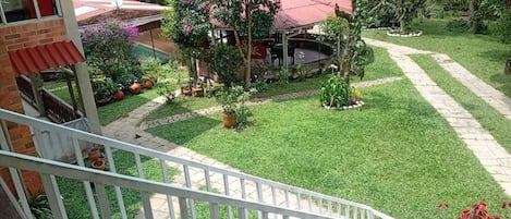 Un jardín cuidado con un área de patio, un pequeño estanque y una variedad de plantas.