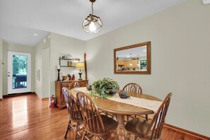 A dining room with a wooden table, chairs, a chandelier, a mirror, and a view of the kitchen. - Sasquatch Beech 3BR Beech Mountain Home- Near Skiing- Fire pit- Sleeps 8 (Beech Mountain)