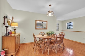 A dining room with a wooden table and chairs, a chandelier, and a mirror on the wall. - Sasquatch Beech 3BR Beech Mountain Home- Near Skiing- Fire pit- Sleeps 8 (Beech Mountain)