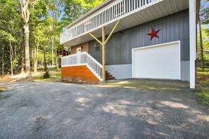 Un bâtiment à deux étages, doté d’un balcon blanc, d’une décoration en forme d’étoile rouge et d’une porte de garage blanche.