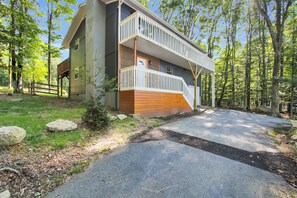 A two-story building with a balcony, surrounded by a forested area. - Sasquatch Beech 3BR Beech Mountain Home- Near Skiing- Fire pit- Sleeps 8 (Beech Mountain)
