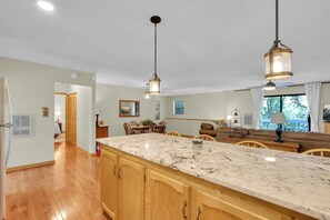 A spacious kitchen with wooden cabinets, a marble countertop, and pendant lighting. - Sasquatch Beech 3BR Beech Mountain Home- Near Skiing- Fire pit- Sleeps 8 (Beech Mountain)