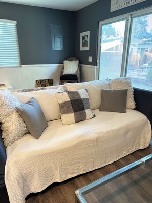 A living room with a sofa, pillows, a chair, a window, and a door. - Fantastic 2-bedroom house with AC in sunny Los Angeles (Los Angeles)