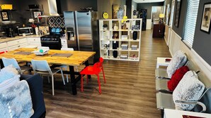 A modern kitchen with a dining area, stainless steel appliances, and a white shelving unit with decorative items. - Fantastic 2-bedroom house with AC in sunny Los Angeles (Los Angeles)