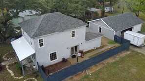 A two-story house with a covered porch and a fenced yard. - Perfect 4-bedroom house with AC in quaint Aransas Pass (Aransas Pass)
