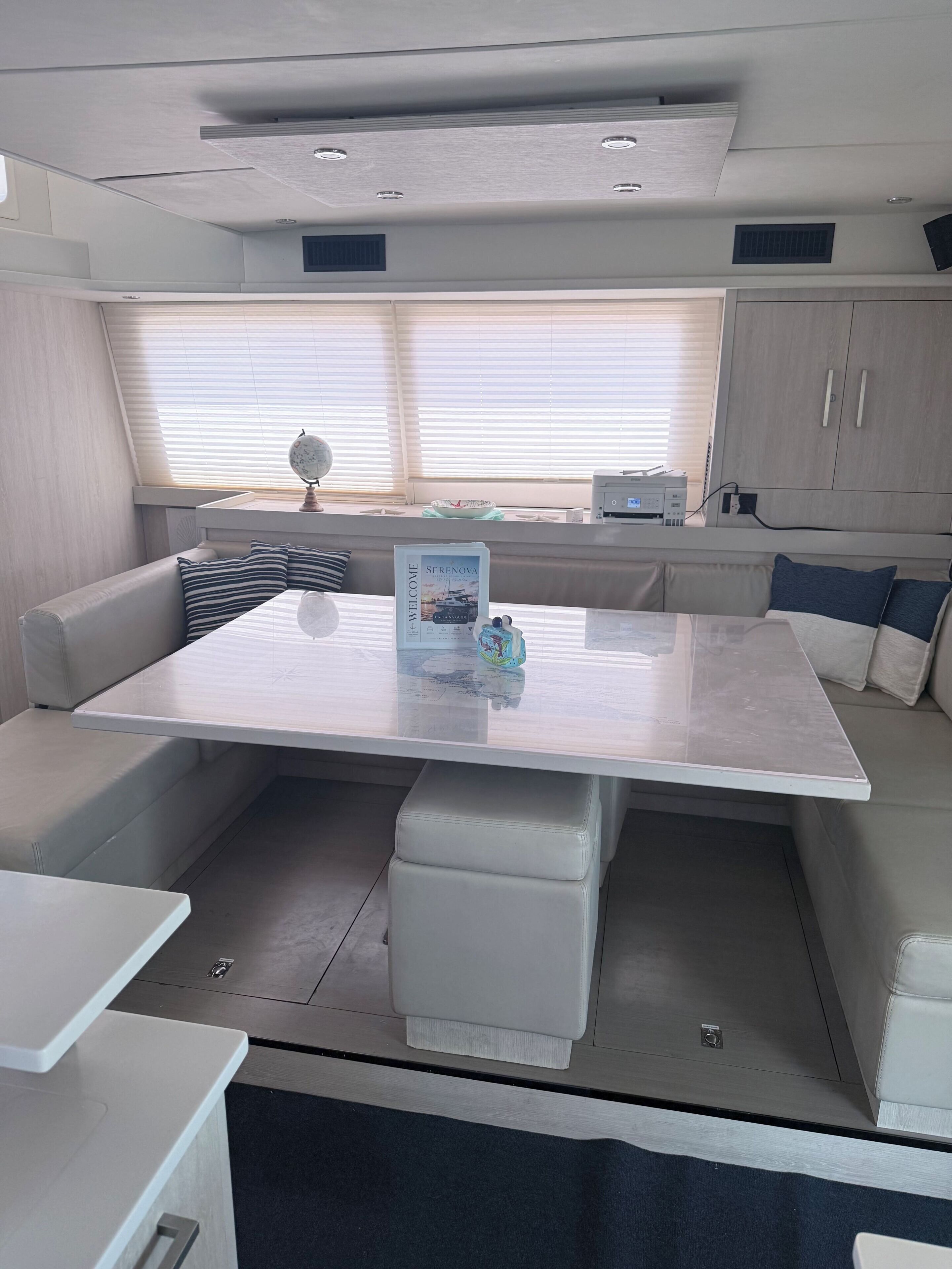 A modern interior with a central seating area, a dining table, and a kitchenette.