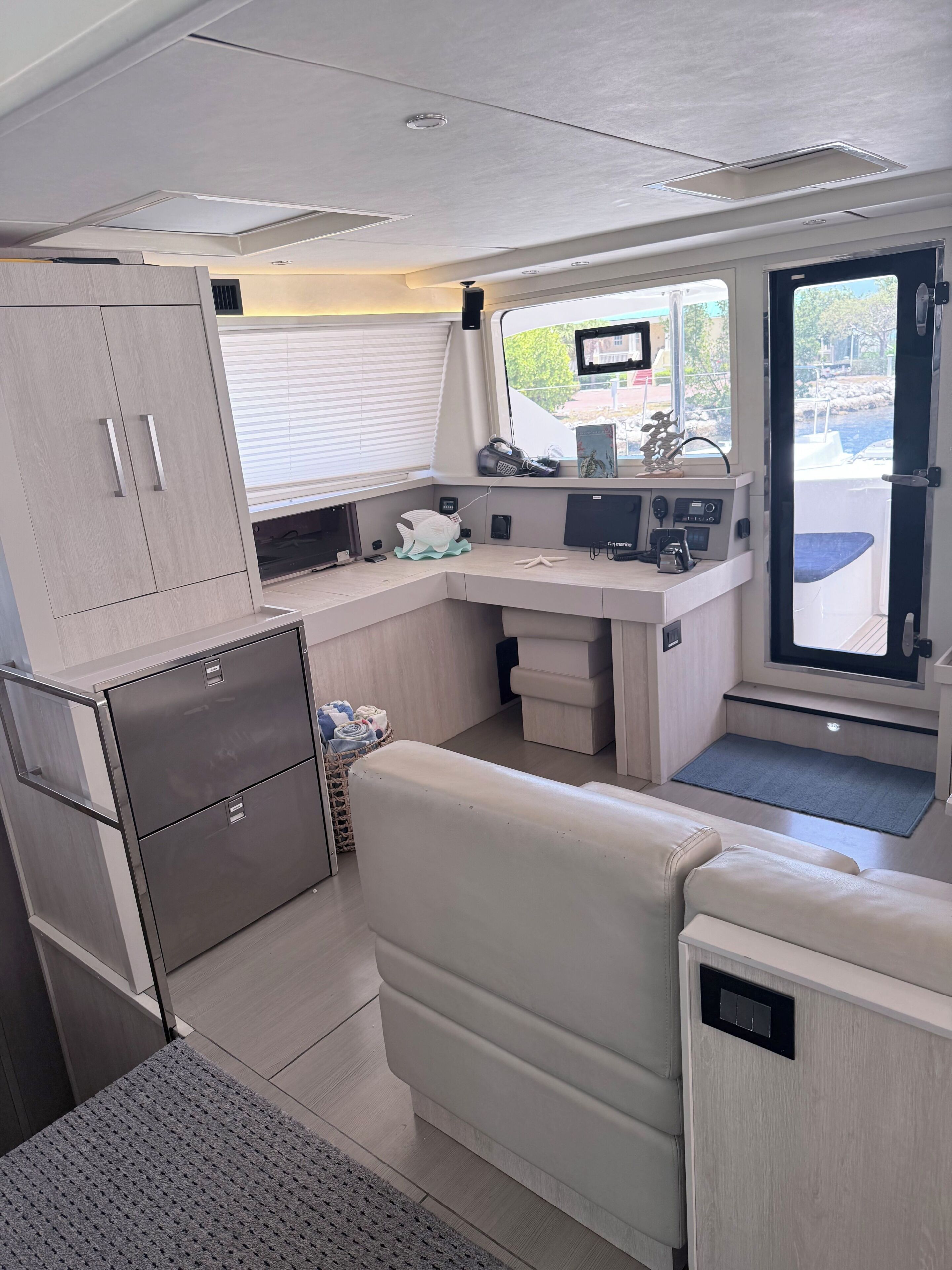 Un espace cuisine compact comprenant un réfrigérateur, un four à micro-ondes et un évier. Une fenêtre offre une vue sur l’extérieur.