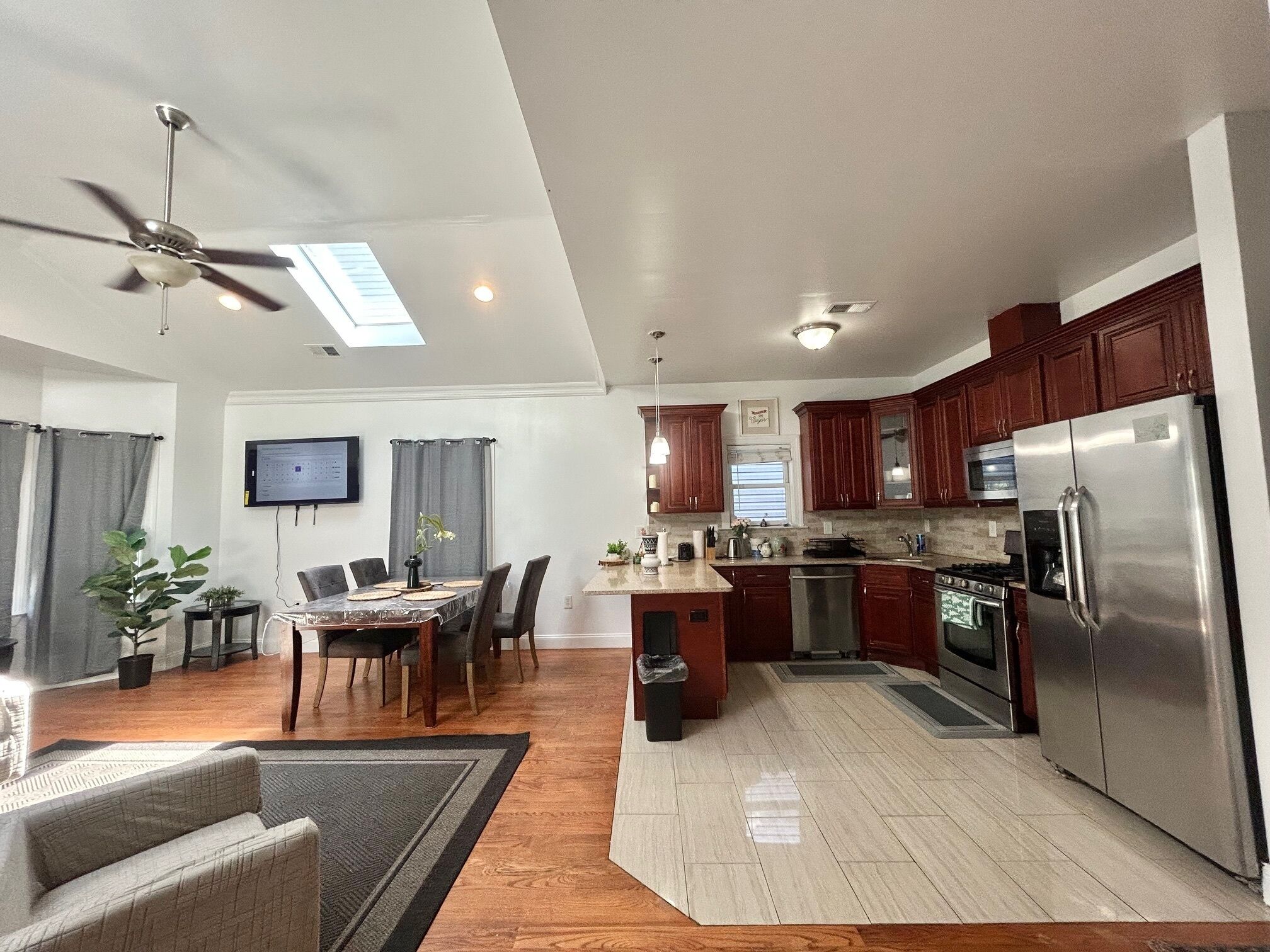 Una cocina moderna con una isla central, electrodomésticos integrados y un comedor con mesa y sillas.