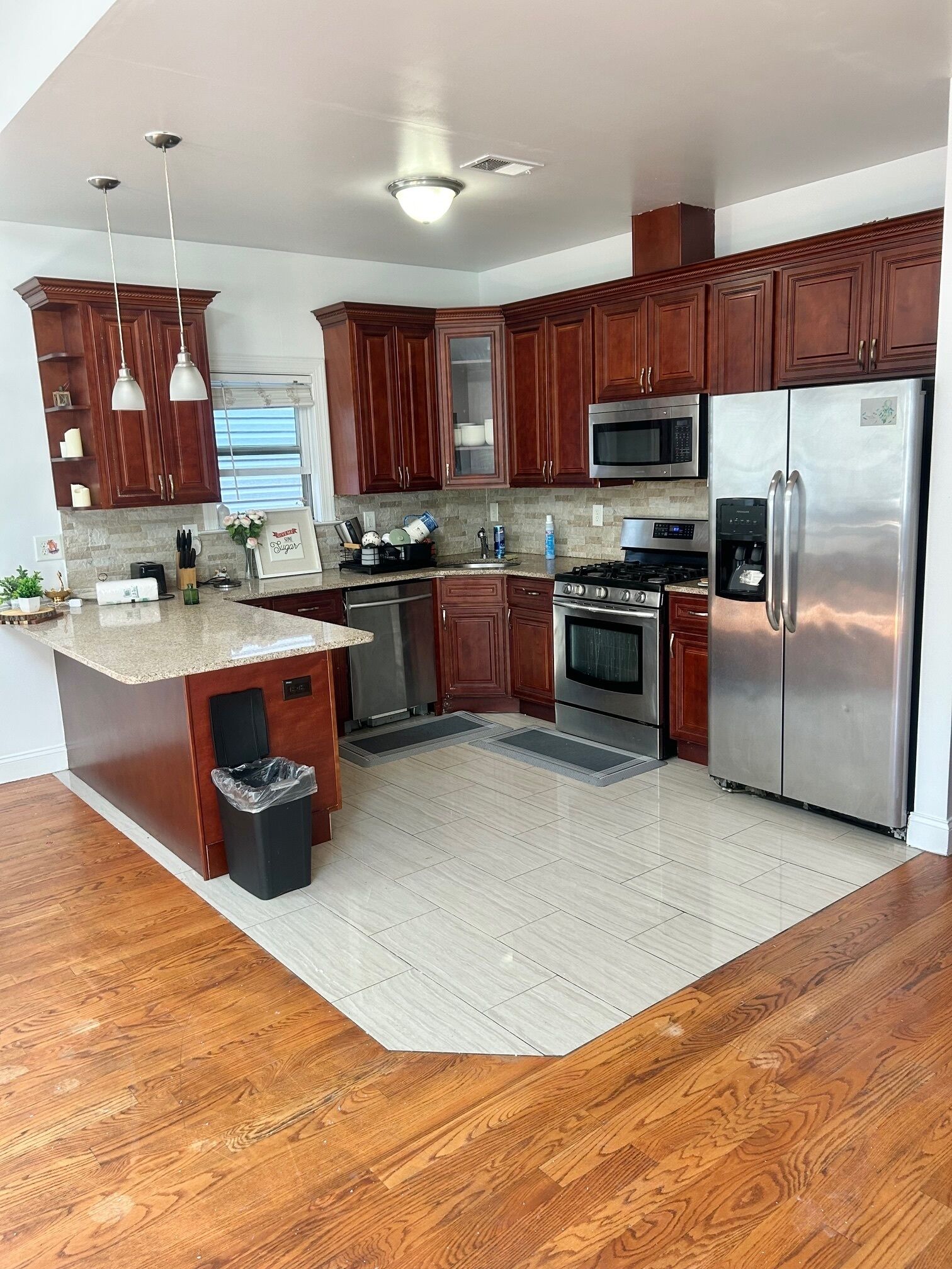 A modern kitchen with wooden cabinets, stainless steel appliances, and a granite countertop.